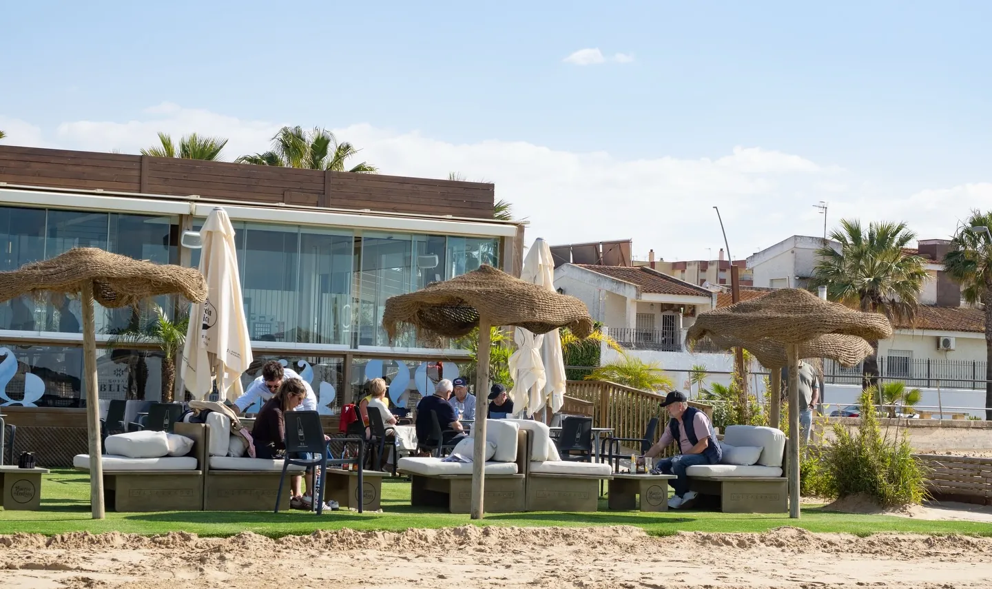 Terraza con sombrillas de palma sobre el césped